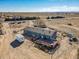 Aerial view of the blue house with a deck, trailer and pool at 16491 County Road 32, Platteville, CO 80651