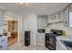 Well-lit kitchen features updated grey cabinets, laminate countertops, and newer appliances at 16491 County Road 32, Platteville, CO 80651