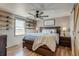 Cozy main bedroom featuring a ceiling fan, wood floors, floating shelves, and a decorative 