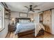 Stylish main bedroom with ceiling fan, floating shelves, wood floors, and barn-door access to the bathroom at 16491 County Road 32, Platteville, CO 80651