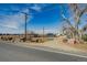 View of the property with a home, vintage trucks, and an American flag near the road at 16491 County Road 32, Platteville, CO 80651