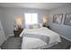 Comfortable bedroom features cozy carpet, neutral walls, and decorative lamps on wooden nightstands at 5585 W 51St Pl, Denver, CO 80212