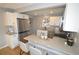 Modern kitchen with stainless steel appliances, white cabinets, and bar-style seating at 5585 W 51St Pl, Denver, CO 80212