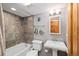 Clean bathroom with tub, shower, tiled walls, pedestal sink and storage shelves at 805 Columbine Rd # 202, Breckenridge, CO 80424