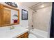 Well lit bathroom with tiled shower and tub, wood vanity, and neutral walls at 805 Columbine Rd # 202, Breckenridge, CO 80424