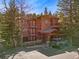 Beautiful three-story condo building with a rustic design and an open parking area at 805 Columbine Rd # 202, Breckenridge, CO 80424