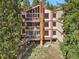 Exterior shot of condo with many balconies surrounded by trees at 805 Columbine Rd # 202, Breckenridge, CO 80424