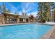 Large pool surrounded by timber framed pool house and mature trees at 805 Columbine Rd # 202, Breckenridge, CO 80424