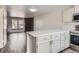 Modern kitchen featuring laminate countertops, updated cabinets, and an open view to living area at 9618 W Chatfield Ave # B, Littleton, CO 80128