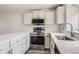 Updated kitchen featuring stainless steel appliances, light cabinetry, and laminate countertops at 9618 W Chatfield Ave # B, Littleton, CO 80128
