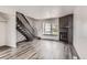 Bright living room with sleek gray floors, a modern fireplace, and staircase at 9618 W Chatfield Ave # B, Littleton, CO 80128