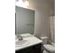 Standard bathroom with white countertop, dark cabinet, framed mirror, and shower-tub combo at 226 S Shady Grove Ct, Aurora, CO 80018