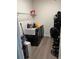 Functional laundry room with black washer and dryer, laminate floor, and shelving at 226 S Shady Grove Ct, Aurora, CO 80018