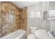 This bathroom showcases a tile shower, tub, toilet, and sink with a window for natural lighting at 4764 High St, Denver, CO 80216