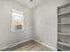 A cozy bedroom features a window with blinds, light wood floors, and a built-in shelving unit at 4764 High St, Denver, CO 80216