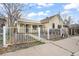 Charming yellow home with white trim and a decorative wrought iron fence at 4764 High St, Denver, CO 80216