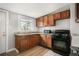 A functional kitchen boasts brown cabinets, granite countertops, and black appliances at 4764 High St, Denver, CO 80216