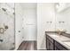 New bathroom featuring a standing shower with glass door, a large mirror, and granite countertops at 9274 Biscay St, Commerce City, CO 80022