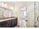 Bright bathroom featuring double vanity with modern fixtures and walk-in shower with marble surround at 9274 Biscay St, Commerce City, CO 80022