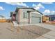 Beautiful home exterior showcasing an attached garage, modern brick accents, and long driveway at 9274 Biscay St, Commerce City, CO 80022