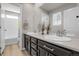 Bright bathroom featuring double sinks with dark cabinetry and a separate tub and shower at 1174 Williams Loop, Elizabeth, CO 80107