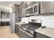 Modern kitchen featuring stainless steel appliances, granite countertops, and dark cabinetry and light wood floors at 1174 Williams Loop, Elizabeth, CO 80107