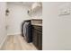 Laundry room with front-load washer and dryer, built-in counter space, and tile floors at 1174 Williams Loop, Elizabeth, CO 80107