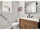 Stylish half bathroom featuring a wood vanity, marble countertop and modern fixtures at 1174 Williams Loop, Elizabeth, CO 80107