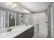 Elegant bathroom featuring a double sink vanity, and a glass-enclosed walk-in shower at 7958 Tejon St, Denver, CO 80221