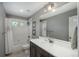 Bathroom featuring a shower/tub combination, a large mirror, and a dark cabinet vanity at 7958 Tejon St, Denver, CO 80221