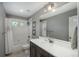 Bathroom featuring tiled shower/tub combo, updated vanity, and a large mirror at 7958 Tejon St, Denver, CO 80221