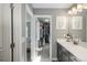 Bathroom featuring a dark cabinet vanity, and a view of the closet through an open door at 7958 Tejon St, Denver, CO 80221