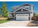 Inviting two-story home with an attached garage, well-maintained lawn, and appealing architectural details at 7958 Tejon St, Denver, CO 80221