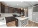 Stylish kitchen with dark cabinets, quartz countertops, stainless appliances, and decorative island with pendant lights at 7958 Tejon St, Denver, CO 80221