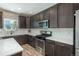 Modern kitchen featuring dark cabinets, white countertops and backsplash, and stainless steel appliances at 7958 Tejon St, Denver, CO 80221