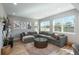Bright living room featuring a cozy gray couch and views to the exterior from plentiful windows at 7958 Tejon St, Denver, CO 80221