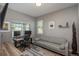 Bright office with two windows, a wooden desk with dual monitors, and a comfortable gray couch at 7958 Tejon St, Denver, CO 80221