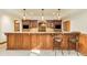 Basement bar features granite counters, custom cabinets, beverage center, and seating at 27 Tamarade Dr, Littleton, CO 80127
