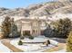 Stunning stone home nestled against a mountain backdrop with mature trees and circular driveway at 27 Tamarade Dr, Littleton, CO 80127