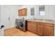 Laundry room featuring front load washer/dryer, oak cabinets, granite countertops, and a utility sink at 27 Tamarade Dr, Littleton, CO 80127