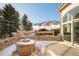 Back patio features stone pavers, brick walls, fire pit, and mountain views at 27 Tamarade Dr, Littleton, CO 80127