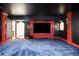 Basement theatre room boasts red trim, sconces, and black walls for a cinematic experience at 27 Tamarade Dr, Littleton, CO 80127