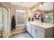 Bright bathroom featuring dual sinks, a large mirror, and a glass-enclosed shower at 8395 E 132Nd Pl, Thornton, CO 80602