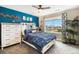 Bright bedroom with a blue accent wall, a comfortable bed, storage, and a view of the outdoors at 8395 E 132Nd Pl, Thornton, CO 80602