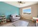 Bright bedroom featuring a sofa, gray carpet, ceiling fan, and colorful book display at 8395 E 132Nd Pl, Thornton, CO 80602