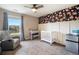 Charming Bedroom featuring a crib, changing table, floral wallpaper, and a large window at 8395 E 132Nd Pl, Thornton, CO 80602