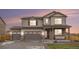 Beautiful two-story home showcasing stone accents, a three-car garage, and manicured landscaping at 8395 E 132Nd Pl, Thornton, CO 80602