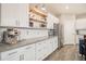 Stylish kitchen with white cabinets, floating wood shelves, and stainless steel appliances at 8395 E 132Nd Pl, Thornton, CO 80602