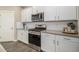 Modern kitchen featuring stainless steel appliances, gray countertops, and ample cabinet space at 8395 E 132Nd Pl, Thornton, CO 80602