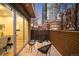 Stylish balcony with outdoor seating, wood railing, and sliding glass door access to an indoor dining area at 33 S Ogden St, Denver, CO 80209